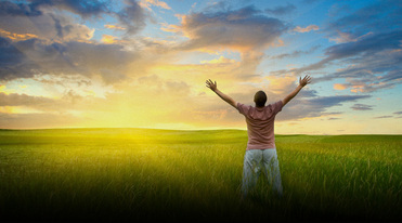 Picture of man in open field holing arms open toward world